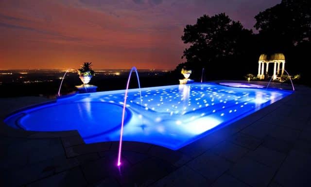 modern infinity-edge pool with underwater LED lighting at dusk