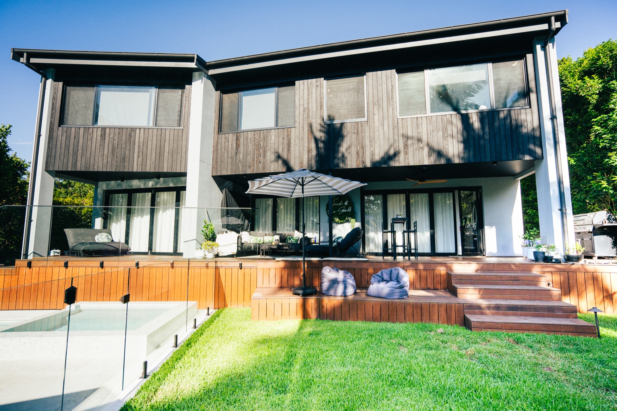 Landscaped backyard lawn and timber deck of a modern home in Sydney